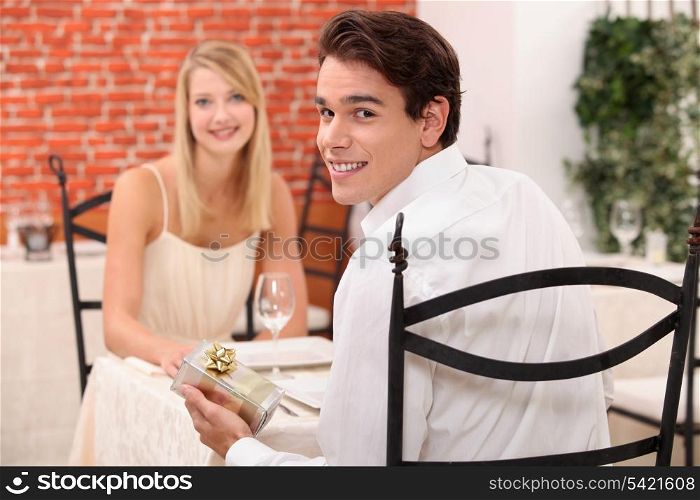 Couple in restaurant with present