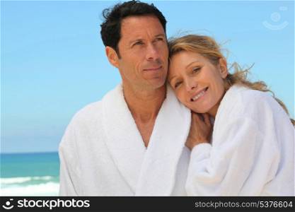 couple in robes at the beach