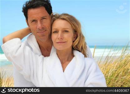 couple in robes on the beach