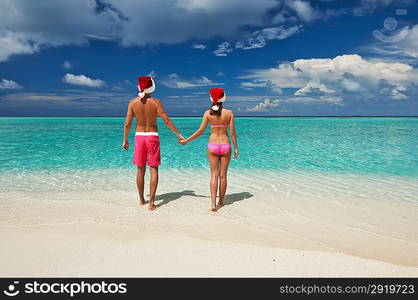 Couple in santa&acute;s hat on a tropical beach at Maldives