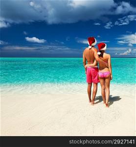 Couple in santa&acute;s hat on a tropical beach at Maldives