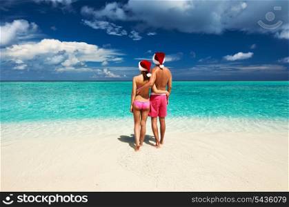 Couple in santa&rsquo;s hat on a tropical beach at Maldives