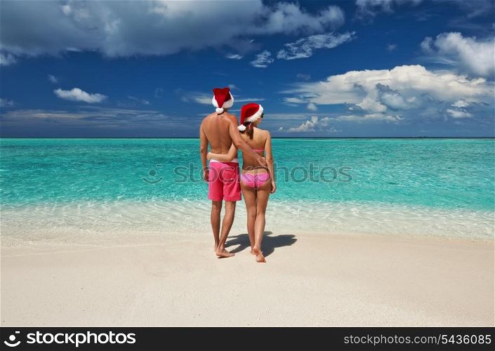 Couple in santa&rsquo;s hat on a tropical beach at Maldives