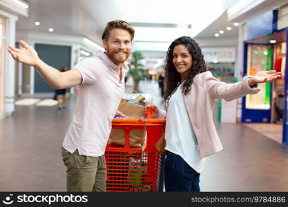 couple in shopping center with their arms outstretched