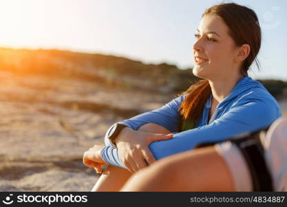 Couple in sport wear on beach. Young coulpe in sport wear sitting on beach