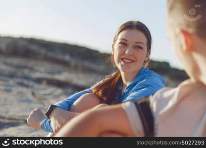 Couple in sport wear on beach. Young coulpe in sport wear sitting on beach