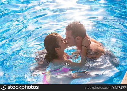 Couple in swimming pool kissing