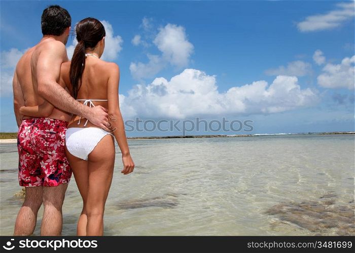 Couple in swimsuit standing by a lagoon