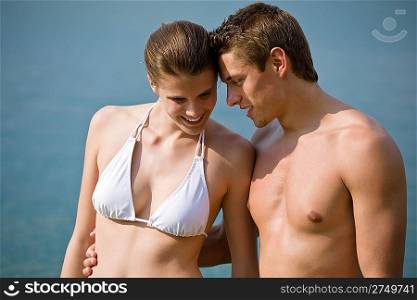 Couple in swimwear enjoy water and sun in summer, standing in sea