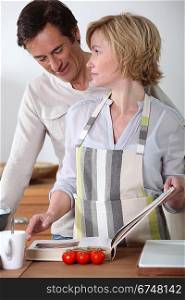 Couple in the kitchen with recipe book