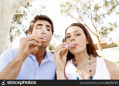 Couple in the park. Happy young couple in the park blowing bubbles