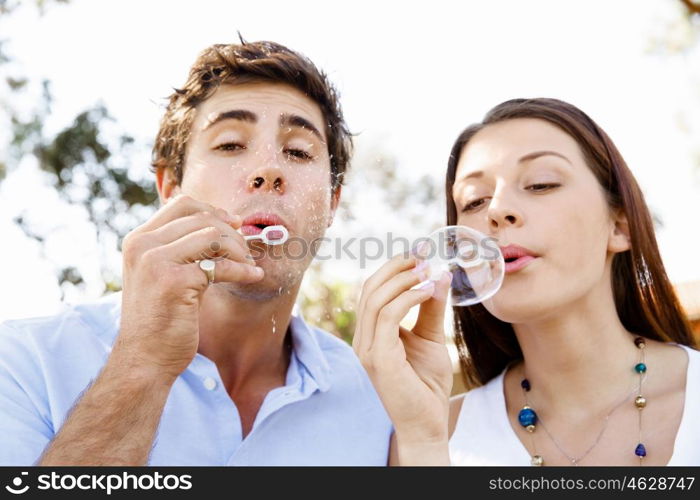 Couple in the park. Happy young couple in the park blowing bubbles