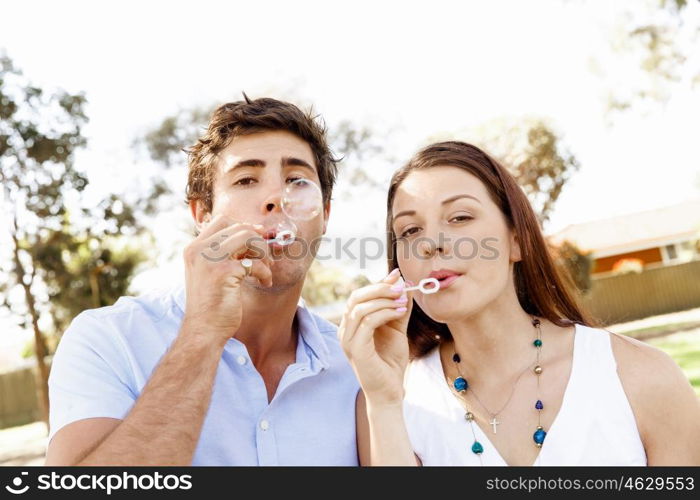 Couple in the park. Happy young couple in the park blowing bubbles