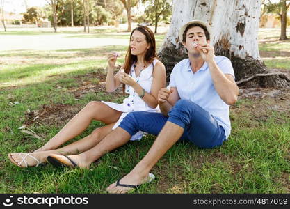 Couple in the park. Happy young couple in the park blowing bubbles