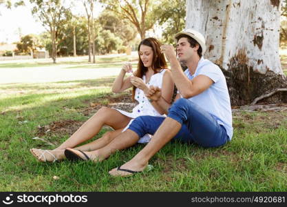 Couple in the park. Happy young couple in the park blowing bubbles