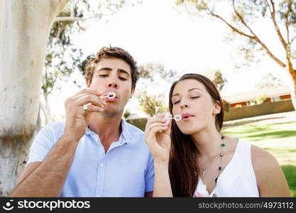 Couple in the park. Happy young couple in the park blowing bubbles