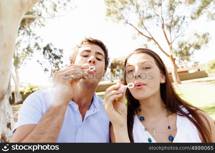 Couple in the park. Happy young couple in the park blowing bubbles