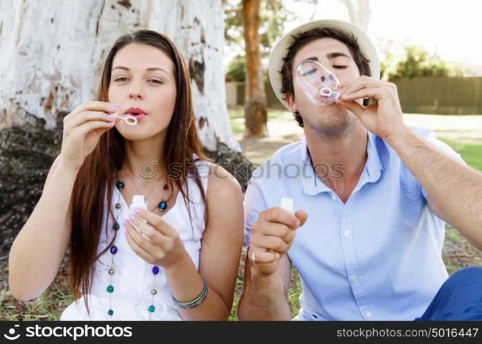 Couple in the park. Happy young couple in the park blowing bubbles