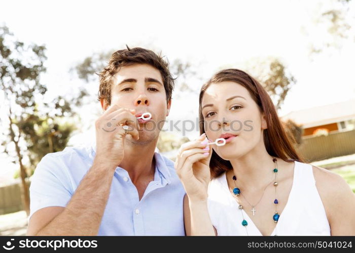 Couple in the park. Happy young couple in the park blowing bubbles