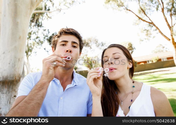 Couple in the park. Happy young couple in the park blowing bubbles