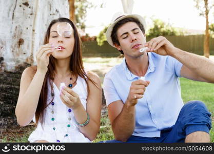 Couple in the park. Happy young couple in the park blowing bubbles