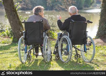 Couple in wheelchairs, looking at the view