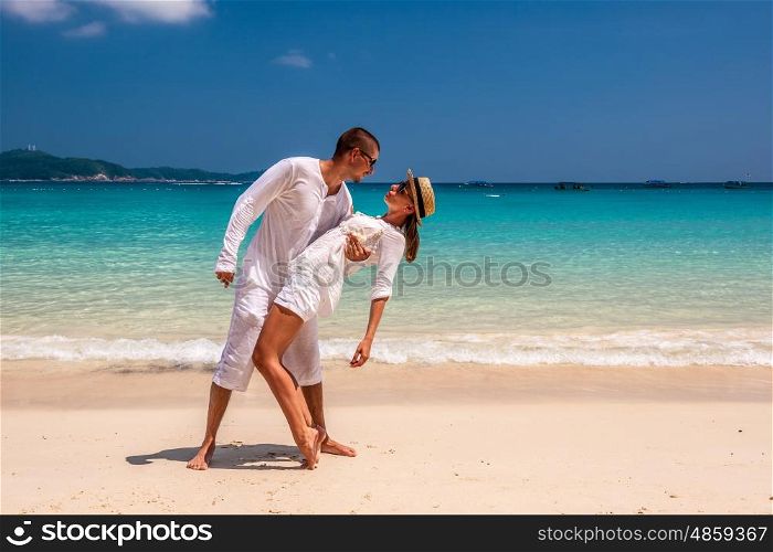 Couple in white having fun on a tropical beach
