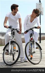 Couple in white on a bicycle