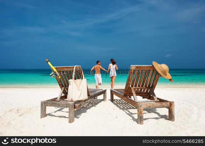 Couple in white running on a tropical beach at Maldives