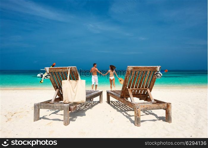 Couple in white running on a tropical beach at Maldives