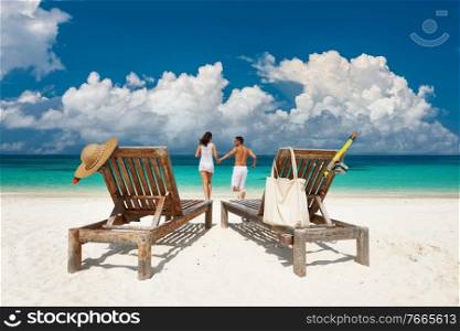 Couple in white running relax on a tropical beach at Maldives