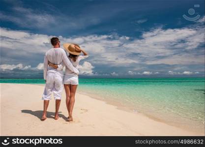 Couple in white walking on a tropical beach at Maldives