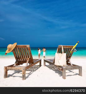 Couple in white walking on a tropical beach at Maldives