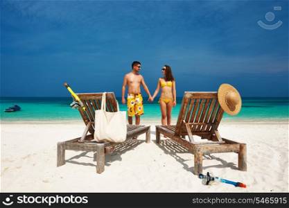 Couple in yellow on a tropical beach at Maldives