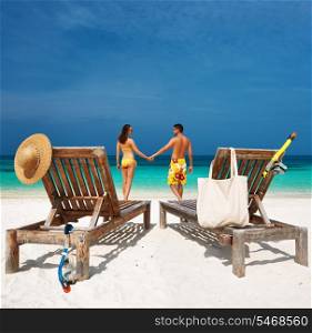 Couple in yellow on a tropical beach at Maldives