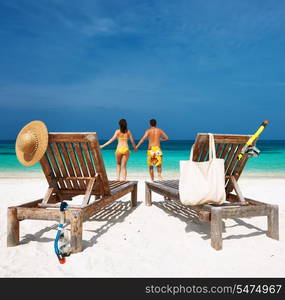 Couple in yellow running on a tropical beach at Maldives