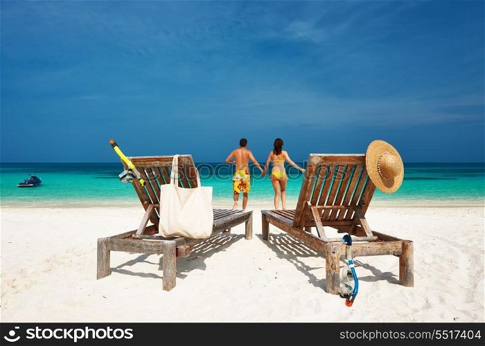 Couple in yellow running on a tropical beach at Maldives