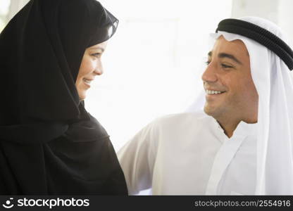 Couple indoors facing each other smiling (high key)