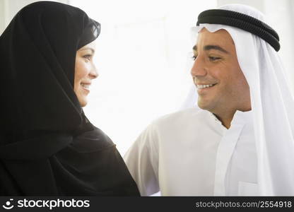 Couple indoors facing each other smiling (high key)