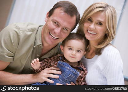 Couple indoors with baby smiling