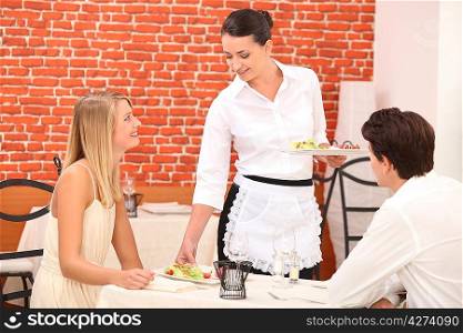 couple interacting with waitress at a dinner
