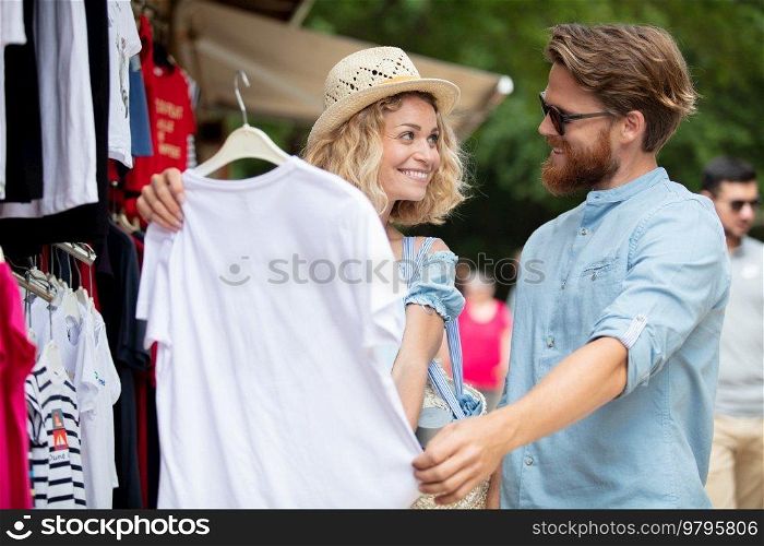 couple is buying a t-shirt outdoors
