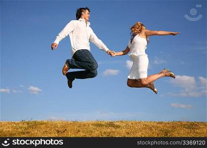 couple jump on meadow