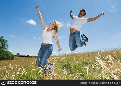 Couple jumping in a field