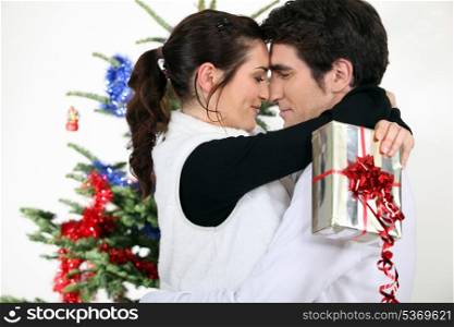 Couple kissing by a Christmas tree