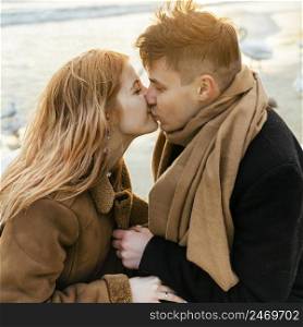couple kissing having fun together beach winter