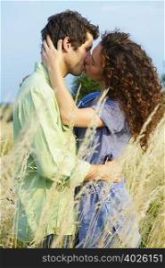 Couple kissing in a wheat field