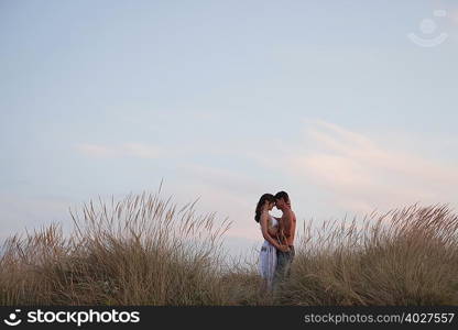 couple kissing in the reed at the beach