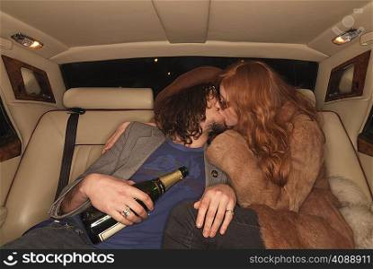 Couple kissing on backseat of luxury car