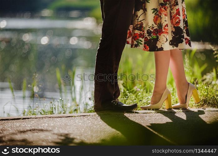 Couple kissing outdoors - Lovers on a romantic date at sunset,girls stands on tiptoe to kiss her man - Close up on shoes.. girls stands on tiptoe to kiss her man - Close up on shoes. selective focus